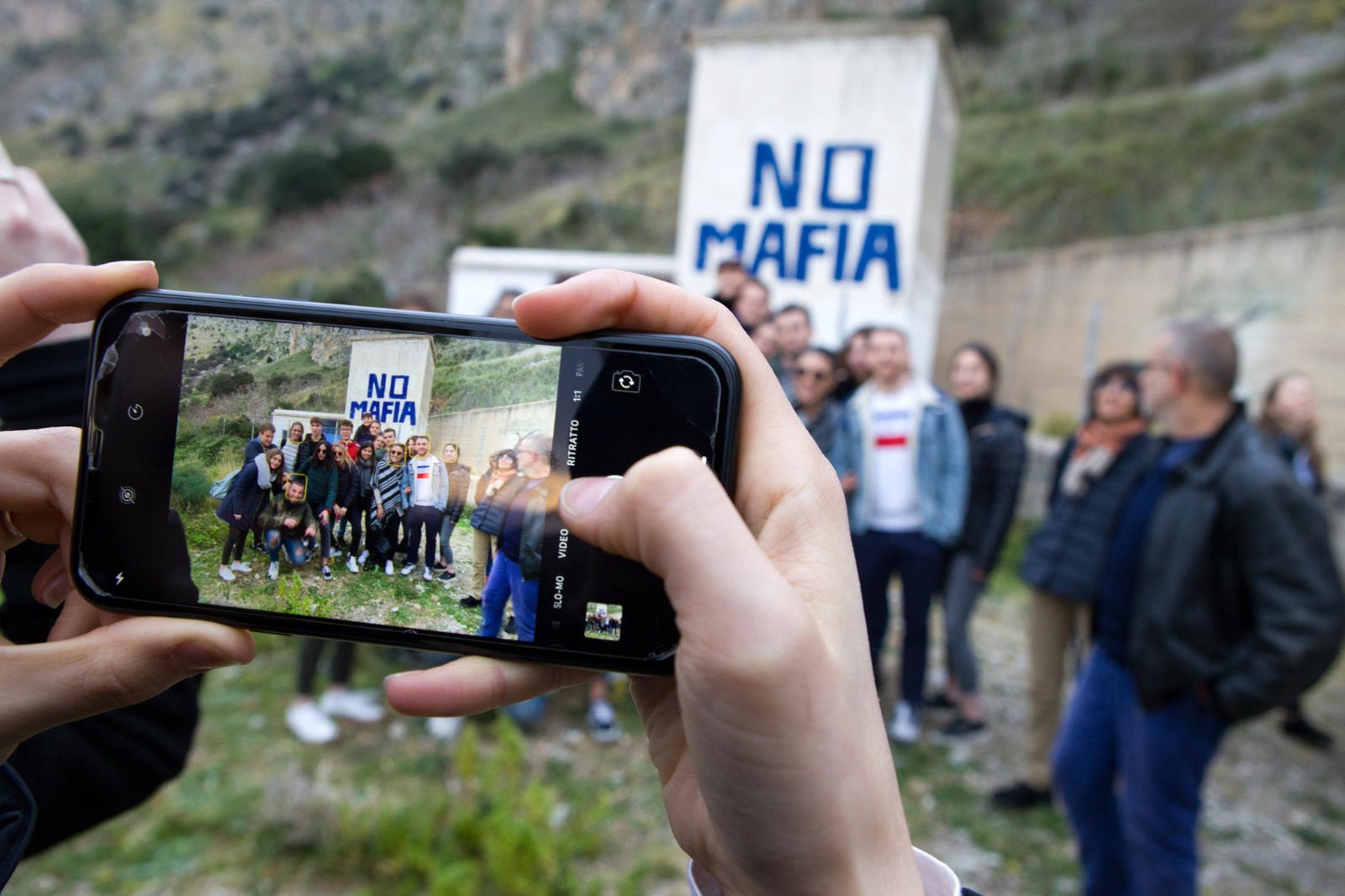 Foto alle persone dell'associazione davanti alla collina NO MAFIA